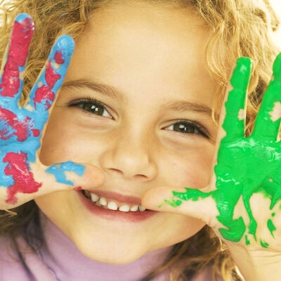 Smiling Girl with Hands Covered in Paint --- Image by &copy; Royalty-Free/Corbis